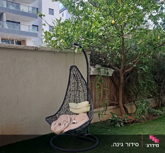 כיסא תלוי בגינה עם עץ לימון ודשא